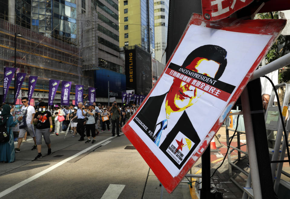 In this July 1, 2018, file photo, a poster of Chinese President Xi Jinping with his eyes blocked by words "Not my president" is seen as thousands of protesters march along a downtown street during an annual pro-democracy protest in Hong Kong. A national security law enacted in 2020 and COVID-19 restrictions have stifled major protests in Hong Kong including an annual march on July 1. (AP Photo/Vincent Yu, File)