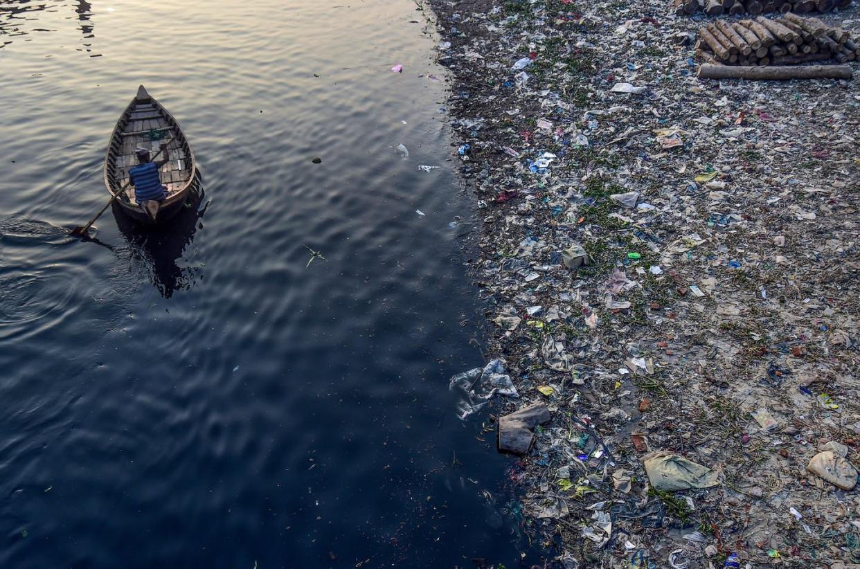 <span class="caption">Plastic trash floating on the Buriganga river in Dhaka, Bangladesh, Jan. 21, 2020</span> <span class="attribution"><a class="link " href="https://www.gettyimages.com/detail/news-photo/man-paddles-on-a-boat-as-plastic-bags-float-on-the-water-news-photo/1195130532" rel="nofollow noopener" target="_blank" data-ylk="slk:Munir Uz Zaman/AFP via Getty Images;elm:context_link;itc:0;sec:content-canvas">Munir Uz Zaman/AFP via Getty Images</a></span>