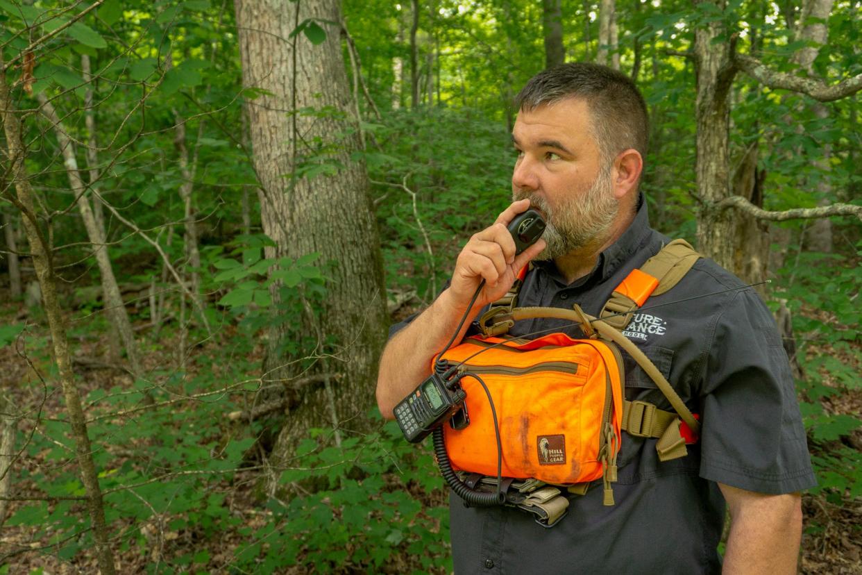 A hiker uses a ham radio to communicate