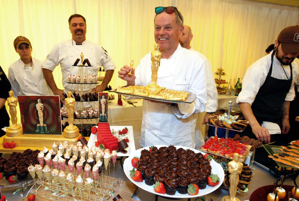 Master Chef Wolfgang Puck, center, holds a tray of 24-karat chocolate Oscars for the 84th Annual Academy Awards Governors Ball at the Oscar food and beverage preview at the Kodak Theatre in Los Angeles on Thursday, Feb. 23, 2012. (AP Photo/Damian Dovarganes)