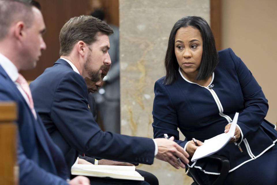 FILE - Fulton County District Attorney Fani Willis, right, talks with a member of her team during proceedings to seat a special purpose grand jury in Fulton County, Georgia, on May 2, 2022, to look into the actions of former President Donald Trump and his supporters who tried to overturn the results of the 2020 election. The hearing took place in Atlanta. (AP Photo/Ben Gray, File)