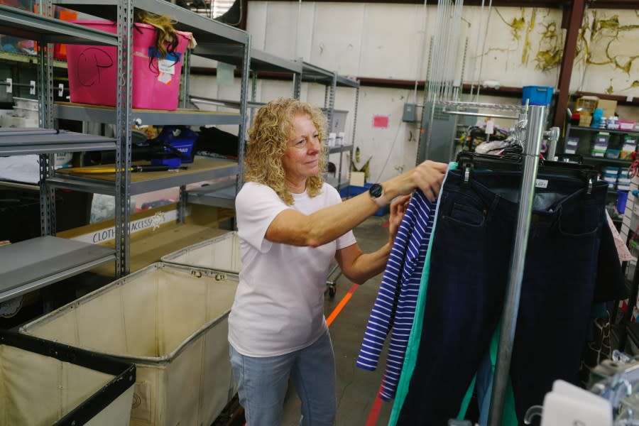 Business Analyst/HR Coordinator Regina Tom sorted through clothes at Three Tails ReSale (photo: Cristina Byrne, WHNT)