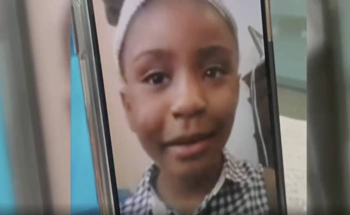 A small Black girl in a gingham top on Facetime.