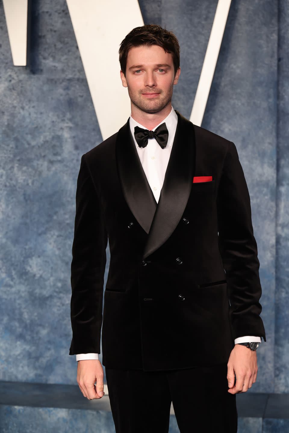 patrick schwarzenegger in a black and white suit on a red carpet