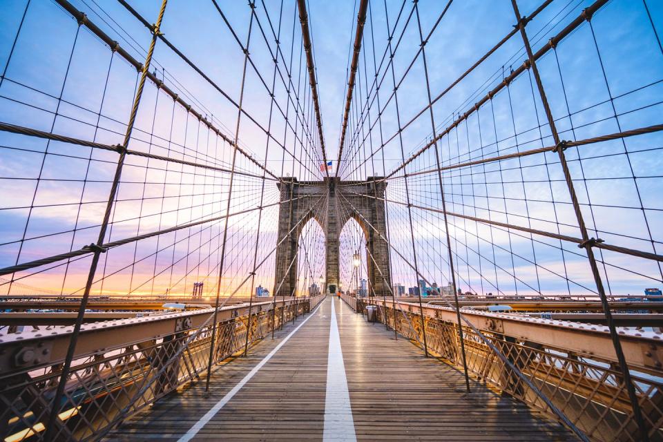 brooklyin bridge's pedestrian walkway at sunrise, new york city