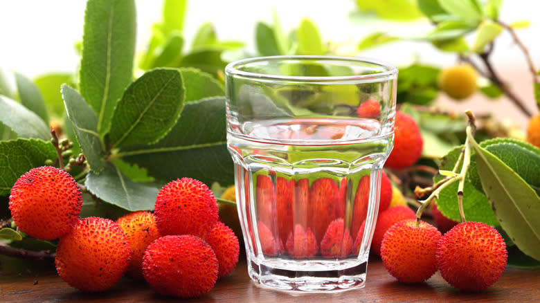 Clear drink in front of red fruits 