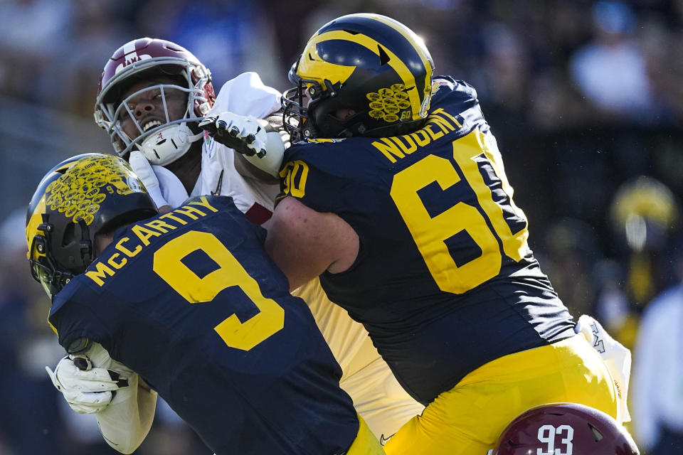 Michigan quarterback J.J. McCarthy (9) is tackled by Alabama defensive lineman Damon Payne Jr. (44) during the first half in the Rose Bowl CFP NCAA semifinal college football game Monday, Jan. 1, 2024, in Pasadena, Calif. (AP Photo/Mark J. Terrill)