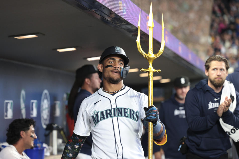 Seattle Mariners' Julio Rodríguez celebrates in the dugout after hitting a two-run home run off Texas Rangers starting pitcher Nathan Eovaldi during the third inning of a baseball game, Saturday, June 15, 2024, in Seattle. (AP Photo/Jason Redmond)