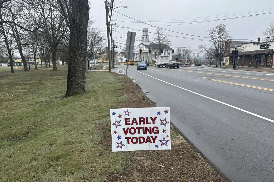 Signs dot the town green in Colchester, Conn., on Wednesday, March 27, 2024, reminding voters they can vote early in the state's presidential primary. It marks the first time voters can vote early and in-person in Connecticut. (AP Photo/Susan Haigh)