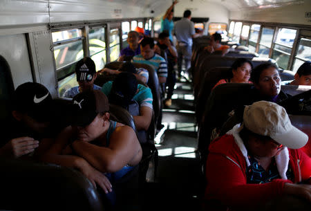 People in a caravan of migrants departing from El Salvador en route to the United States sit inside a bus, in San Salvador, El Salvador, November 18, 2018. REUTERS/Jose Cabezas