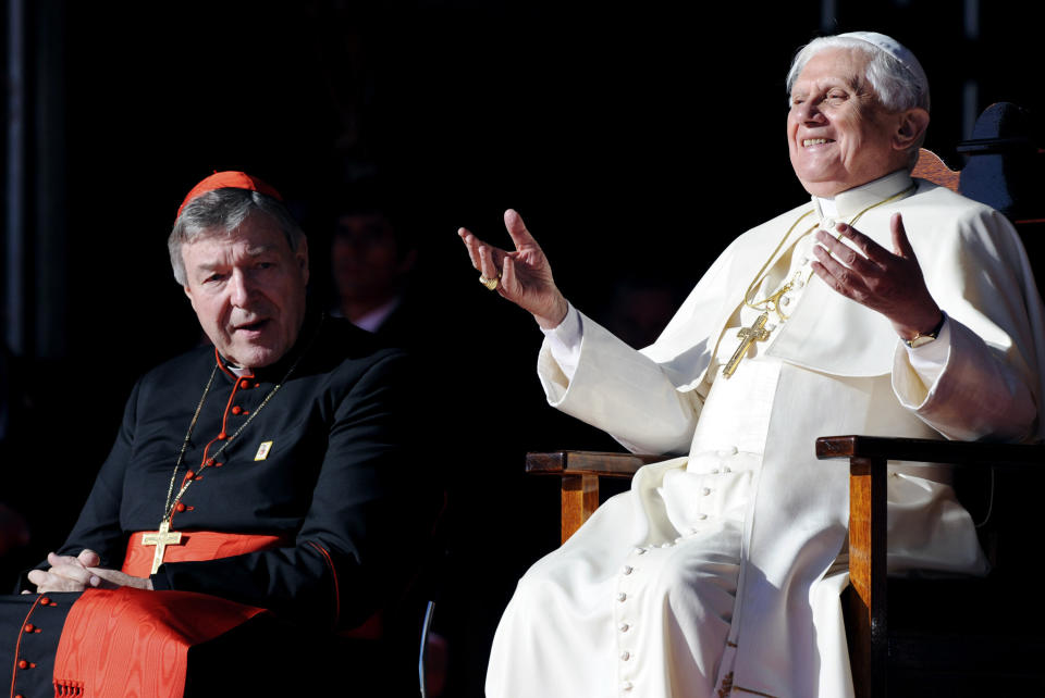 In this July 21, 2008, file photo, then Pope Benedict XVI gestures as he sits with Cardinal George Pell during a ceremony to thank World Youth Day volunteers in Sydney. 