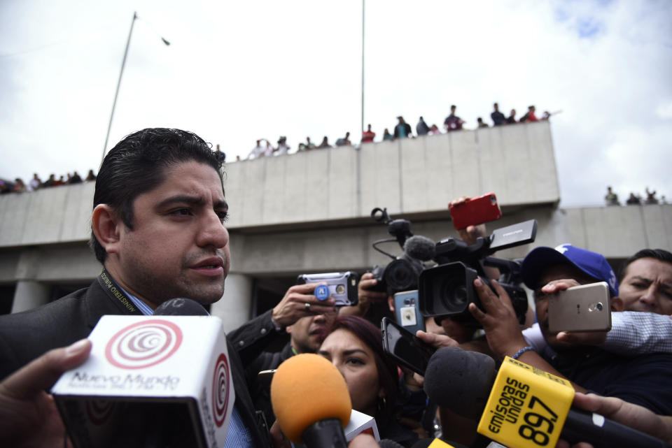 Prosecutor Stuardo Campo, from the Attorney General's office, talks with reporters as he leaves La Aurora International Airport in Guatemala City, Sunday, Jan. 6, 2019. Authorities are holding Colombian national Yilen Osorio, a member of CICIG, in the capital's airport, refusing him entry to the country in an escalation of tensions between the government and the commission. (AP Photo/Santiago Billy)