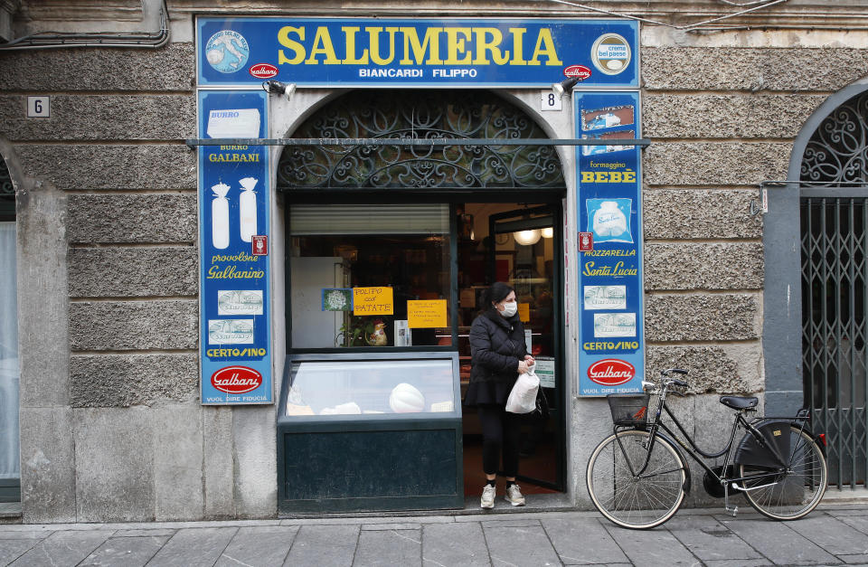 In this photo taken on Thursday, March 12, 2020, a woman gets out of a deli meat and cold cuts shop in Codogno, Italy. The northern Italian town that recorded Italy’s first coronavirus infection has offered a virtuous example to fellow Italians, now facing an unprecedented nationwide lockdown, that by staying home, trends can reverse. Infections of the new virus have not stopped in Codogno, which still has registered the most of any of the 10 Lombardy towns Italy’s original red zone, but they have slowed. For most people, the new coronavirus causes only mild or moderate symptoms. For some it can cause more severe illness. (AP Photo/Antonio Calanni)