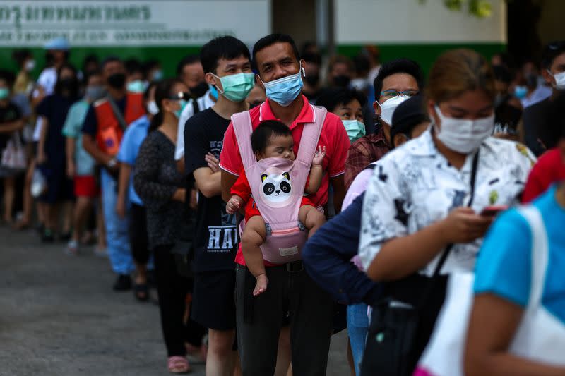 People line up for their early vote for Thailand's upcoming general election at a polling station in Bangkok