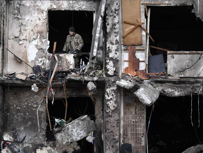 A Ukrainian serviceman is seen in the window of a damaged residential building at Koshytsa Street, a suburb of the Ukrainian capital Kyiv, where a military shell allegedly hit, on February 25, 2022