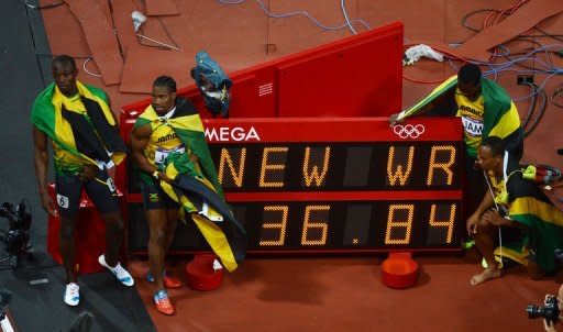 Jamaica's Usain Bolt, Nesta Carter, Yohan Blake and Michael Frater pose for pictures near the New World Record sign after they won the gold medal in the men's 4x100m relay final at the athletics event of the London 2012 Olympic Games