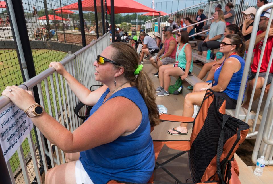 Erika Monroe, front, from Ft. Wayne, Ind., cheers on her daughter's team as softball fans gather in the bleachers during the United States Specialty Sports Association (USSSA) Fastpitch Great Lakes Nationals softball tournament at Deaconess Sports Park Friday morning, July 17, 2020.