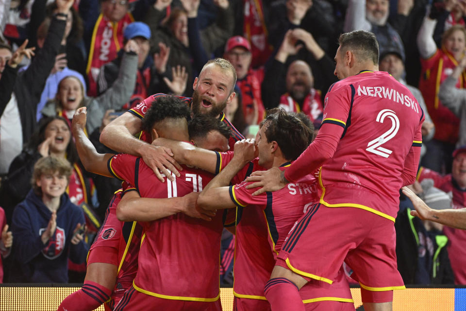 Members of St. Louis City SC celebrate after scoring a goal against Charlotte FC during the first half of an MLS soccer match Saturday, March 4, 2023, in St. Louis. (AP Photo/Joe Puetz)