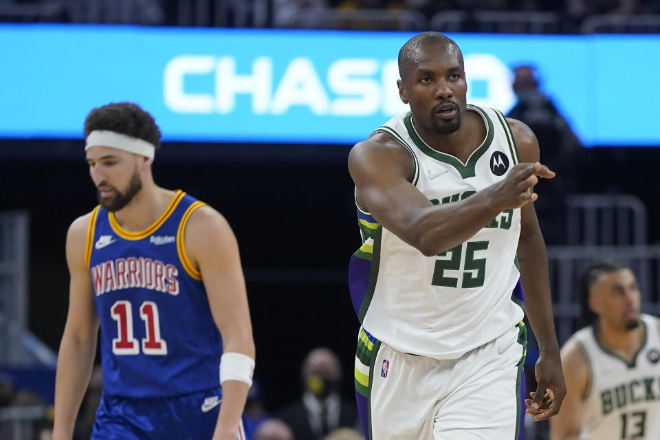 Milwaukee Bucks center Serge Ibaka (25) gestures after shooting a 3-point basket next to Golden State Warriors guard Klay Thompson (11) during the first half of an NBA basketball game in San Francisco, Saturday, March 12, 2022. (AP Photo/Jeff Chiu)