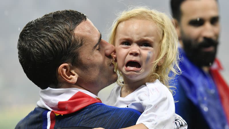 France’s Antoine Griezmann carries his crying daughter after his team won the final match between France and Croatia at the 2018 soccer World Cup in the Luzhniki Stadium in Moscow, Russia, Sunday, July 15, 2018.