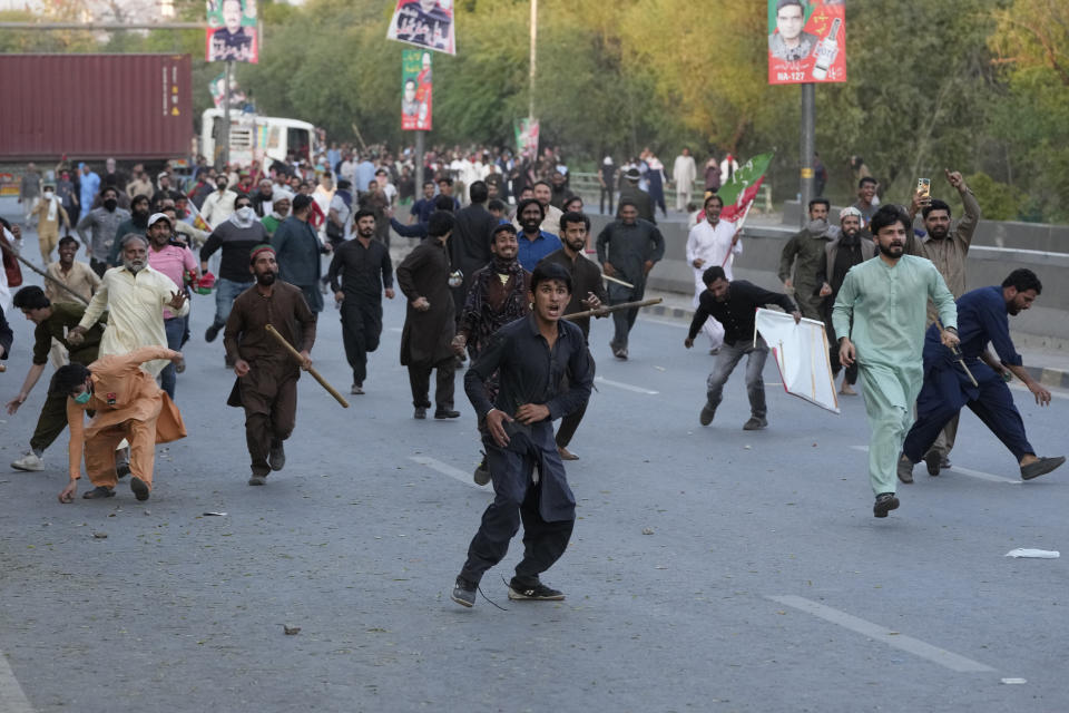 Supporters of Pakistan's former Prime Minister Imran Khan throw stones toward police during a clashes, in Lahore, Pakistan, Wednesday, March 8, 2023. Pakistani police used water cannons and fired tear gas to disperse supporters of the country's former Prime Minister Khan Wednesday in the eastern city of Lahore. Two dozen Khan supporters were arrested for defying a government ban on holding rallies, police said. (AP Photo/K.M. Chaudary)