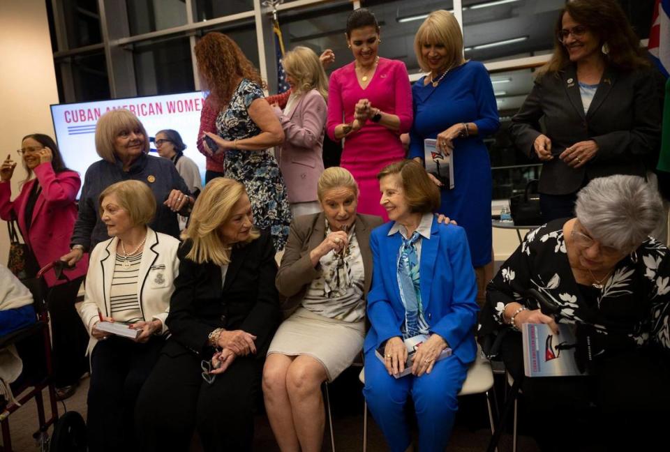 Arnhilda Badía, author of “Cuban American Women: Making History”, center, blue suit, smiles with Eneida Roldán, health care administrator, to the left, and other women she wrote about in her book after a panel discussion on Thursday, Jan. 25, 2024, at Otto G. Richter Library at the University of Miami in Coral Gables.