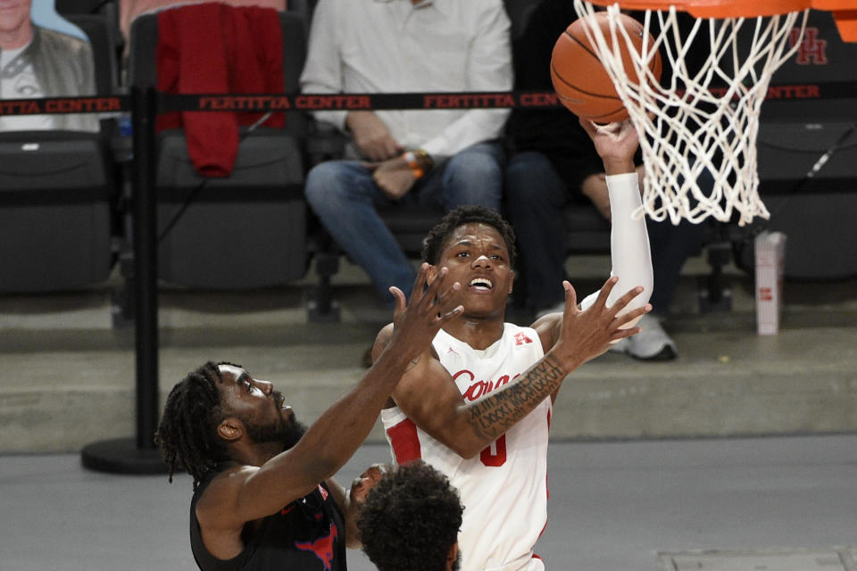 Houston guard Marcus Sasser, right, shoots as SMU guard Emmanuel Bandoumel, left, defends during the first half of an NCAA college basketball game, Sunday, Jan. 31, 2021, in Houston. (AP Photo/Eric Christian Smith)