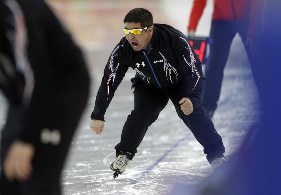 U.S. coach Ryan Shimabukuro urges on one of his athletes competing in the women's 1,500-meter speedskating race at the Adler Arena Skating Center during the 2014 Winter Olympics in Sochi, Russia, Sunday, Feb. 16, 2014. (AP Photo/Patrick Semansky)