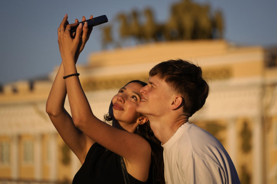 School graduates take a selfie photo in the Palace Square as they take part the Scarlet Sails festivities marking school graduation in St. Petersburg, Russia, Friday, June 24, 2022. (AP Photo/Dmitri Lovetsky)