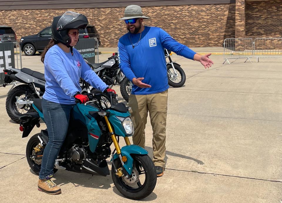 A woman gets help from a team member from the Motorcycle Industry Council, which held a training site in Sturgis where inexperienced motorcycle riders can learn to ride safety in hopes they will become lifelong bikers.