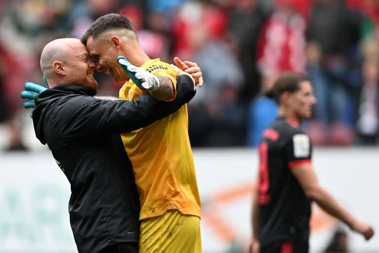 Jonas Scheuermann, asistente técnico del Augsburgo, abraza al arquero Rafal Gikiewicz tras la victoria