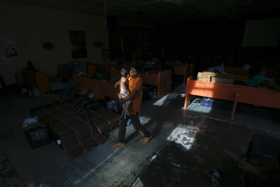 In this July 28, 2019, photo, Anderson Jimenez, of El Salvador, carries his brother Jacob at El Buen Pastor shelter for migrants in Cuidad Juarez, Mexico. (AP Photo/Gregory Bull)