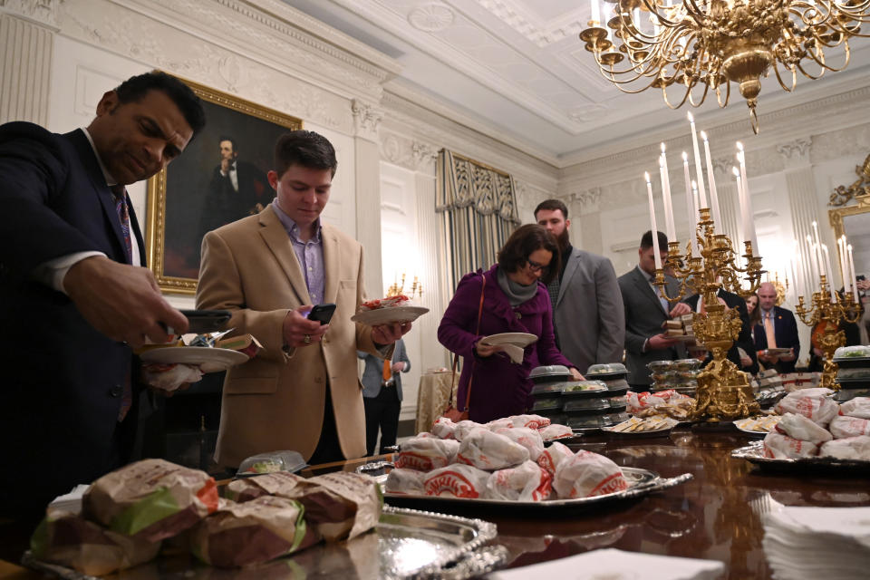 FILE - In this Jan. 14, 2019, file photo, guests attending a reception for the Clemson NCAA college football team grab fast food sandwiches in the State Dining Room of the White House in Washington. (AP Photo/Susan Walsh, File)