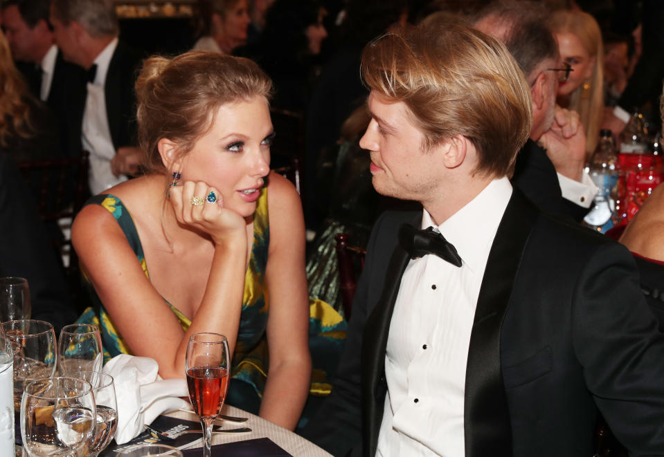 Closeup of Taylor looking at Joe as they sit at a table during a formal event