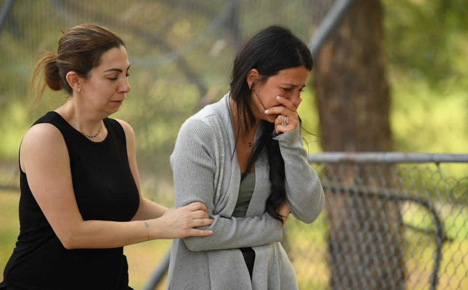 The victims' mother Leila Geagea (right) pauses near flowers placed at the scene where seven children were hit on a footpath by a four-wheel drive in the Sydney suburb of Oatlands on Sunday.