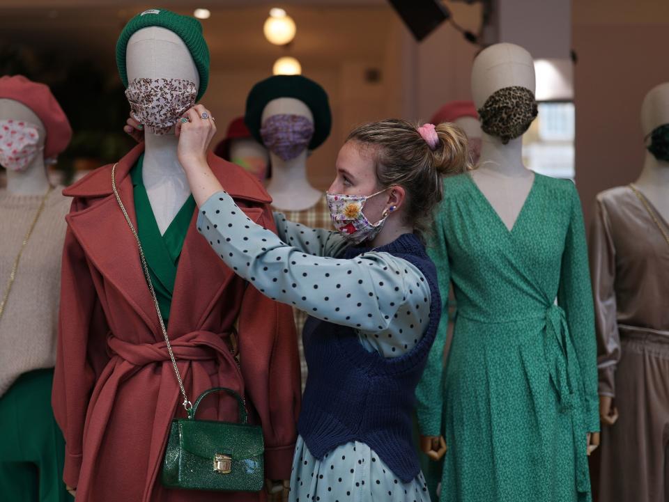 A shop stylist adjusts a face mask on a mannequin in a window display at fashion store ¯ST London, after a range of new coronavirus restrictions came into place in England. (Yui Mok/PA)