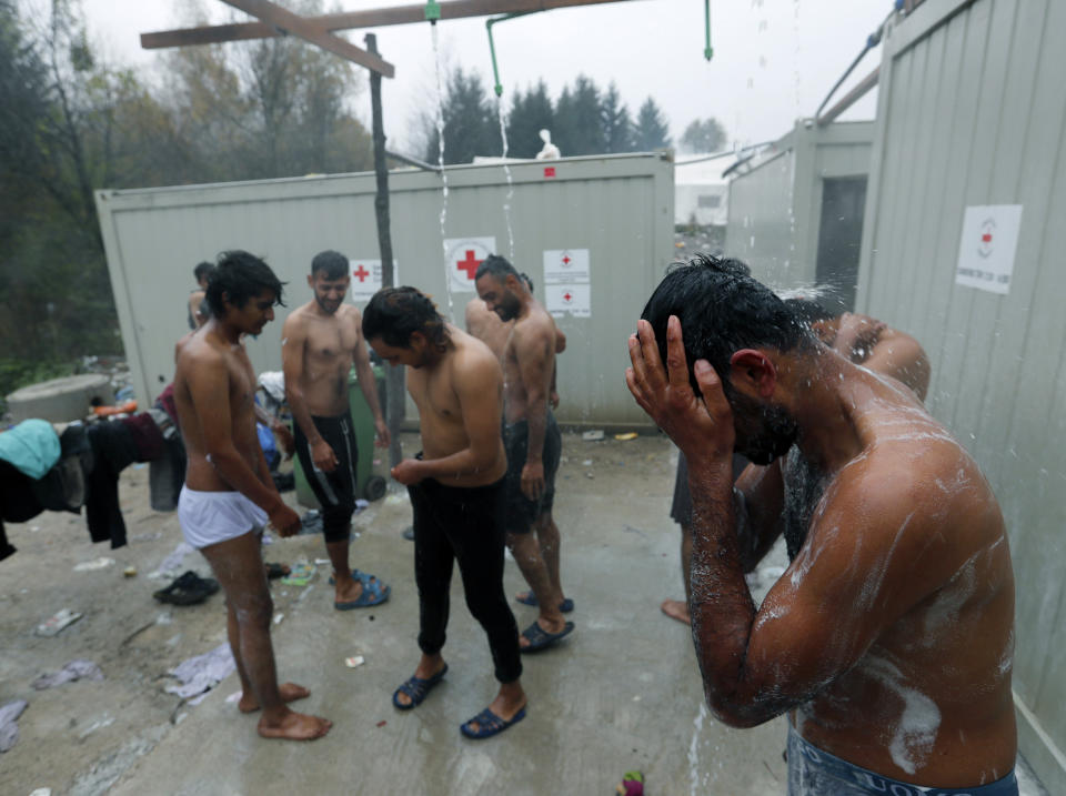 Migrants wash themselves at the Vucjak refugee camp outside Bihac, northwestern Bosnia, Thursday, Nov. 14, 2019. The European Union's top migration official is warning Bosnian authorities of a likely humanitarian crisis this winter due to appalling conditions in overcrowded migrant camps in the country. (AP Photo/Darko Vojinovic)