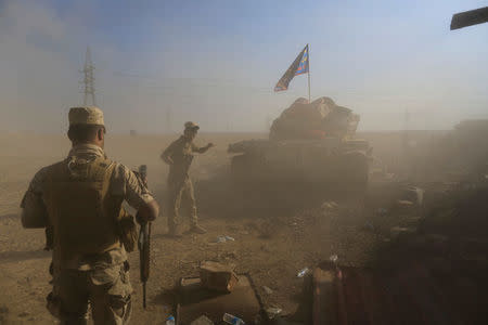 Iraqi soldiers are seen among dust after a tank fired towards Islamic State fighters' position during a battle in the Shahrazed district of eastern Mosul, Iraq November 4, 2016. REUTERS/Zohra Bensemra