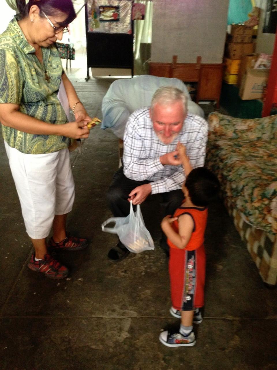 Los Angeles Auxiliary Bishop David O'Connell greets a child in Peru. He traveled there over the years on missionary trips.