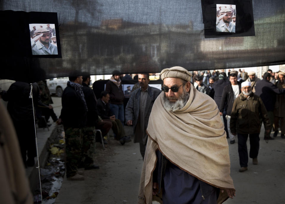 Afghan men arrive to pay their last respect to late Afghan Vice President Field Marshal Mohammed Qasim Fahim outside his house in Kabul, Afghanistan, Monday, March 10, 2014. Afghanistan's influential Vice President Fahim, a leading commander in the alliance that fought the Taliban who was later accused with other warlords of targeting civilian areas during the country's civil war, died March 9, 2014. He was 57. (AP Photo/Anja Niedringhaus)