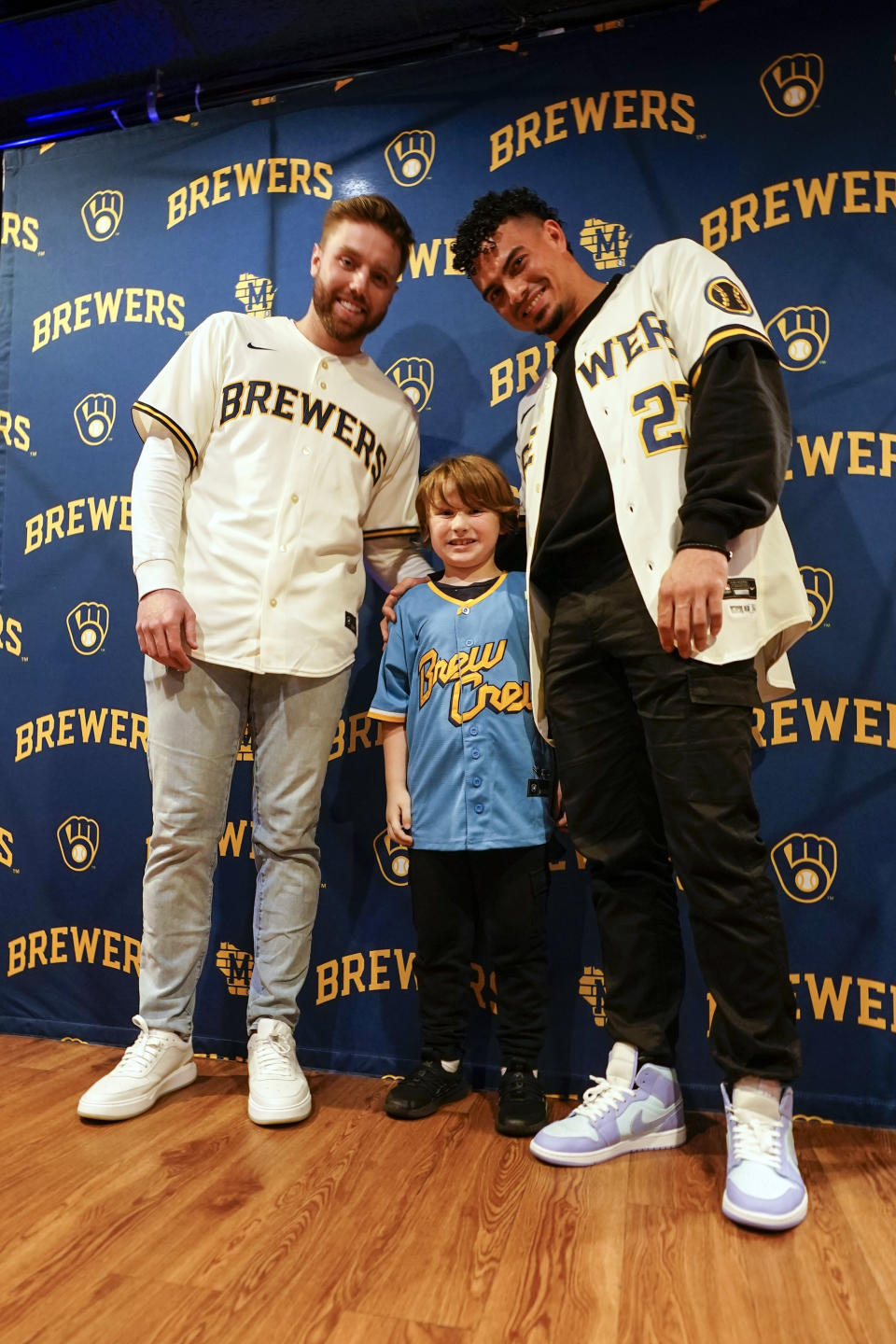 Seven-year-old Adam Lauzon poses for a picture with Milwaukee Brewers' Willy Adames and Owen Miller at a promotional event Wednesday, Jan. 18, 2023, in Milwaukee. (AP Photo/Morry Gash)