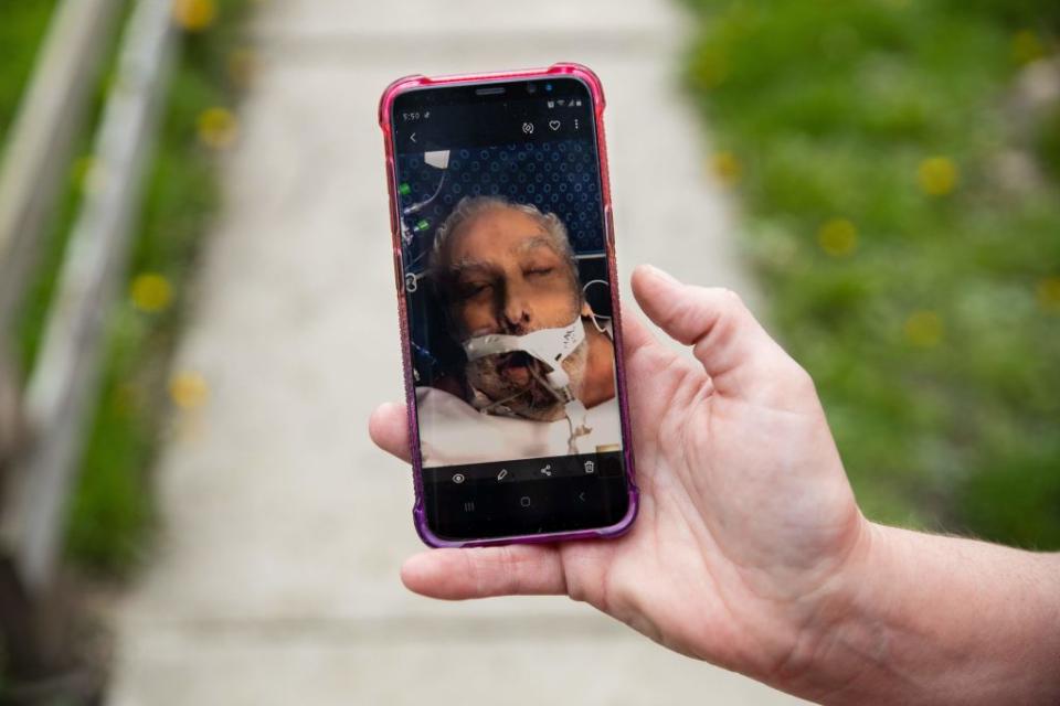 Ohio woman Christine Bevington holds a photo of her stepfather as they said goodbye on a video call before. he passed away from COVID-19 last month. Source: Getty