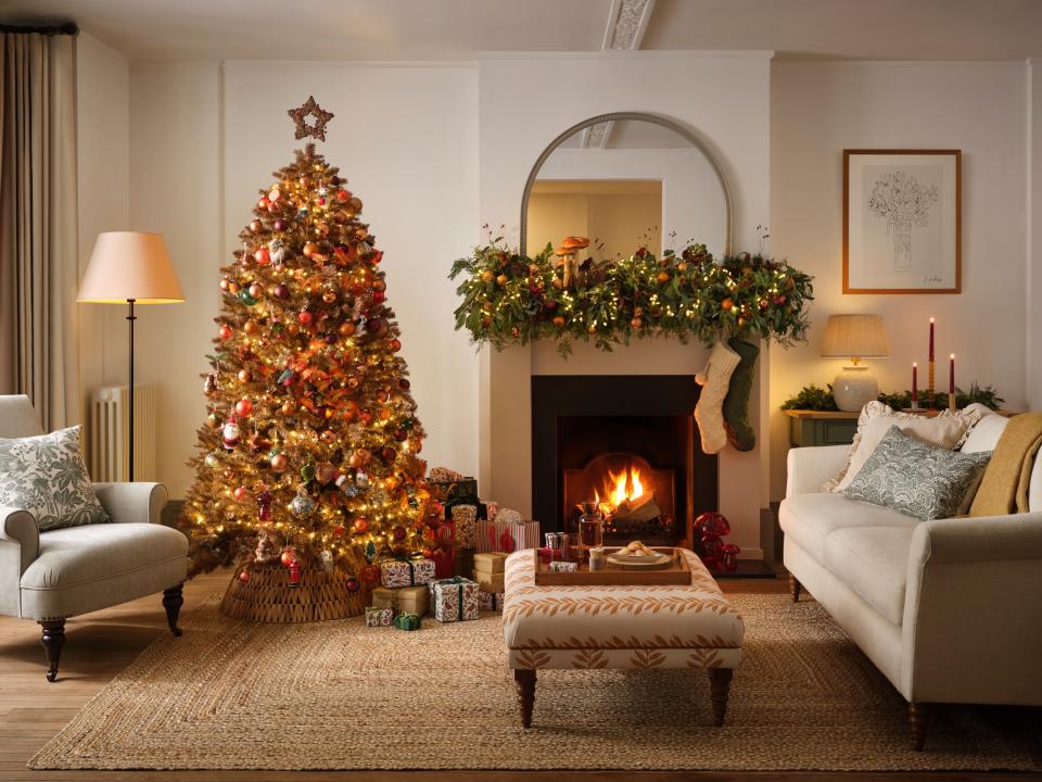 A festive photograph depicting a John Lewis 2023 Christmas tree and garland in an upmarket sitting room. (John Lewis)