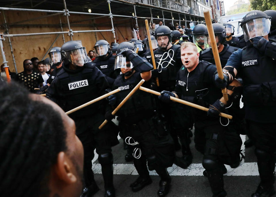 <p>Police armed with clubs face off against counter-protesters.</p>