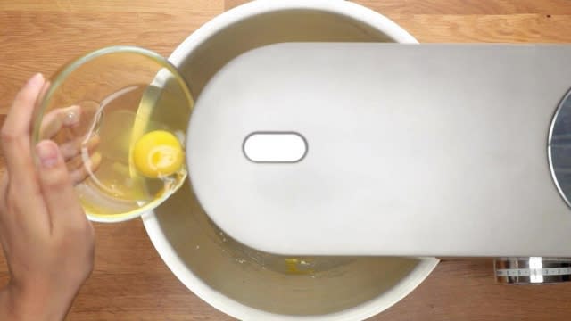 Adding eggs to mixing bowl