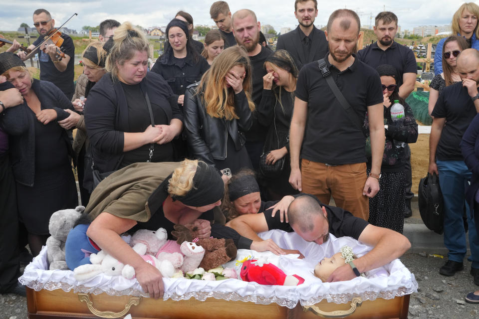 Relatives and friends attend the funeral ceremony for Liza, 4-year-old girl killed by Russian attack, in Vinnytsia, Ukraine, Sunday, July 17, 2022. Wearing a blue denim jacket with flowers, Liza was among 23 people killed, including two boys aged 7 and 8, in Thursday's missile strike in Vinnytsia. Her mother, Iryna Dmytrieva, was among the scores injured. (AP Photo/Efrem Lukatsky)