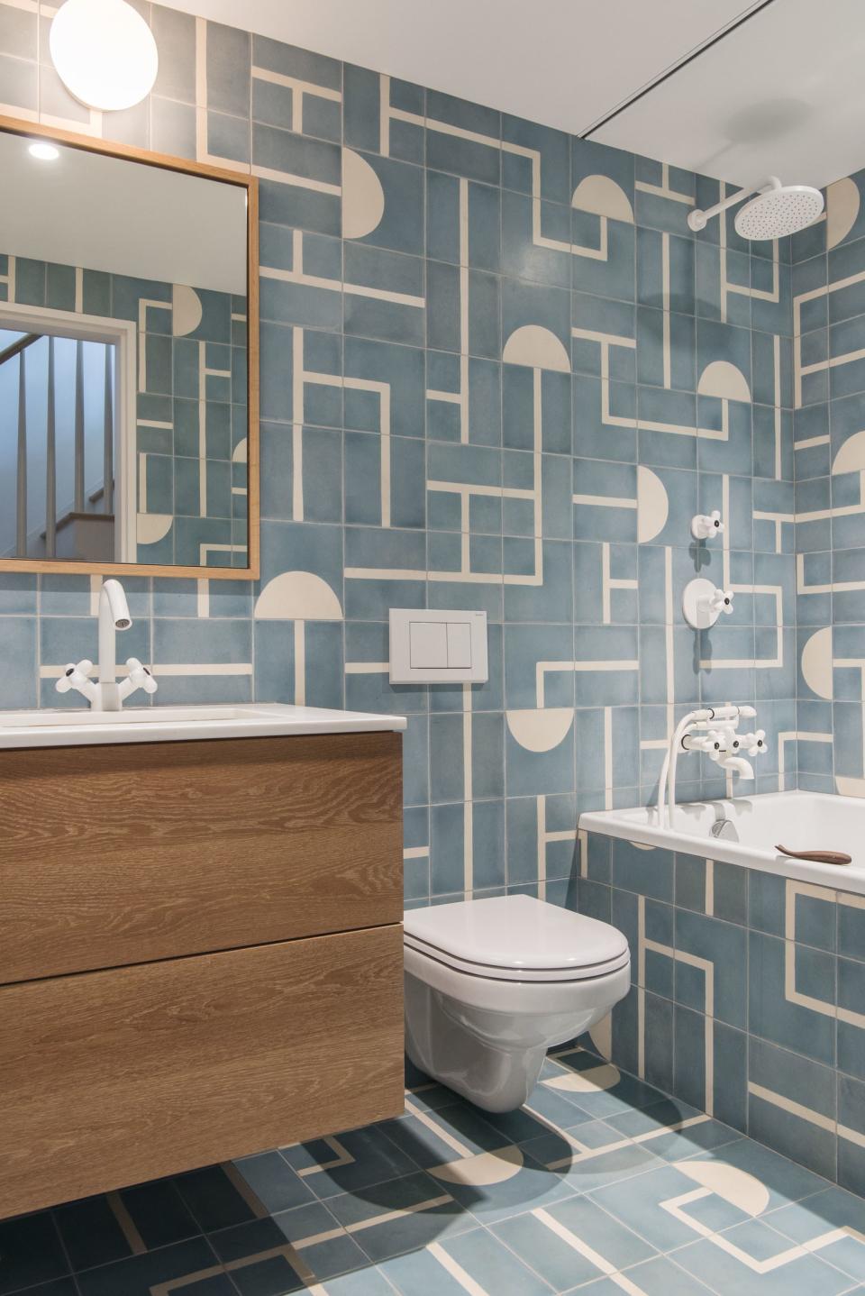 Roberts had fun with the kids' bathroom, covering it floor-to-ceiling in graphic Popham Design Brasilia tiles. "It has no windows, so the client wanted something that was fun and bright," she says. All of the fixtures play off of the pattern: the Jasper Morrison for Flos Glo-Ball sconce is the same diameter as the half-moons and the faucets are a white retro style from Fantini.