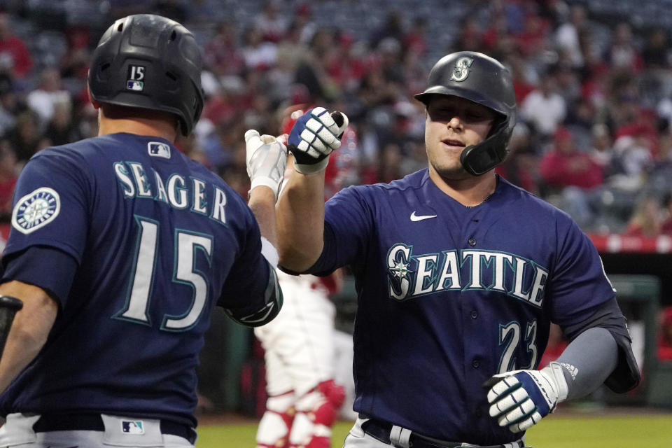 Seattle Mariners' Ty France is congratulated by Kyle Seager after hitting a solo home run during the first inning of a baseball game against the Los Angeles Angels Friday, Sept. 24, 2021, in Anaheim, Calif. (AP Photo/Mark J. Terrill)