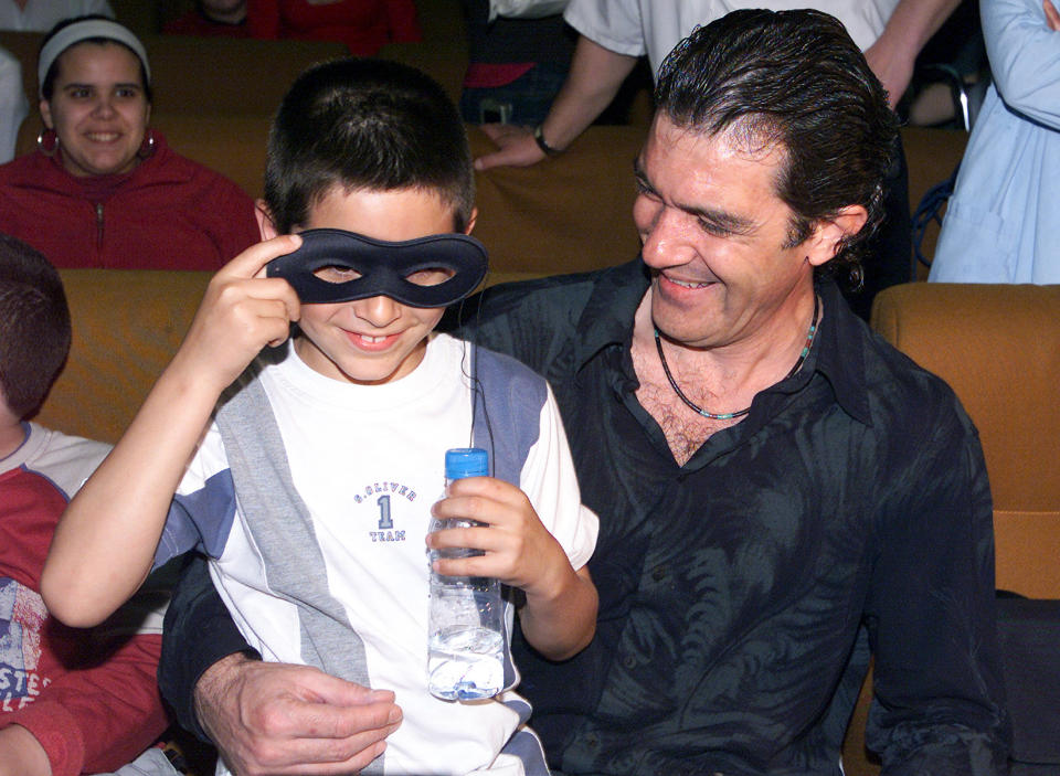 Spanish actor Antonio Banderas entertains a boy with a mask during a flying visit to a children's hospital in Malaga, southern Spain, April 15, 2004. REUTERS/Rafael Marchante MDP/JV