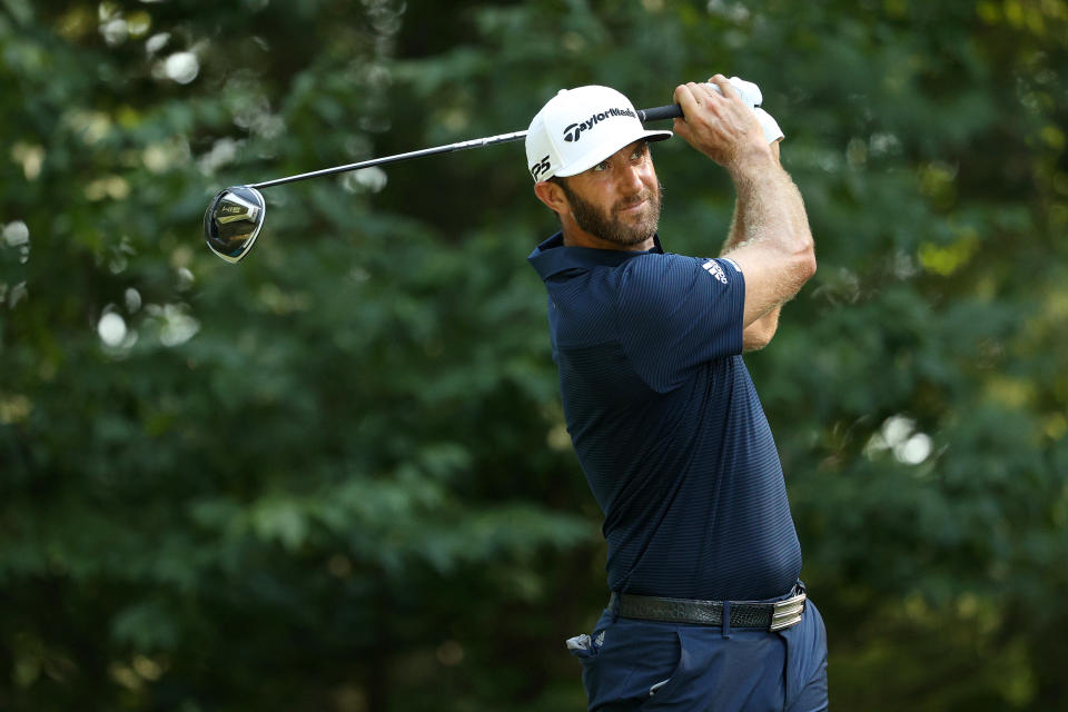 Dustin Johnson watches a shot with his club behind his head. 